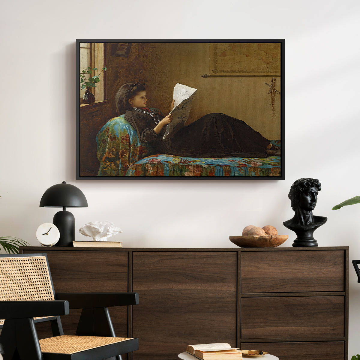 Interesting News, 1872 by Eastman Johnson displayed in a black floater framed canvas above a dark wood credenza in an entryway.