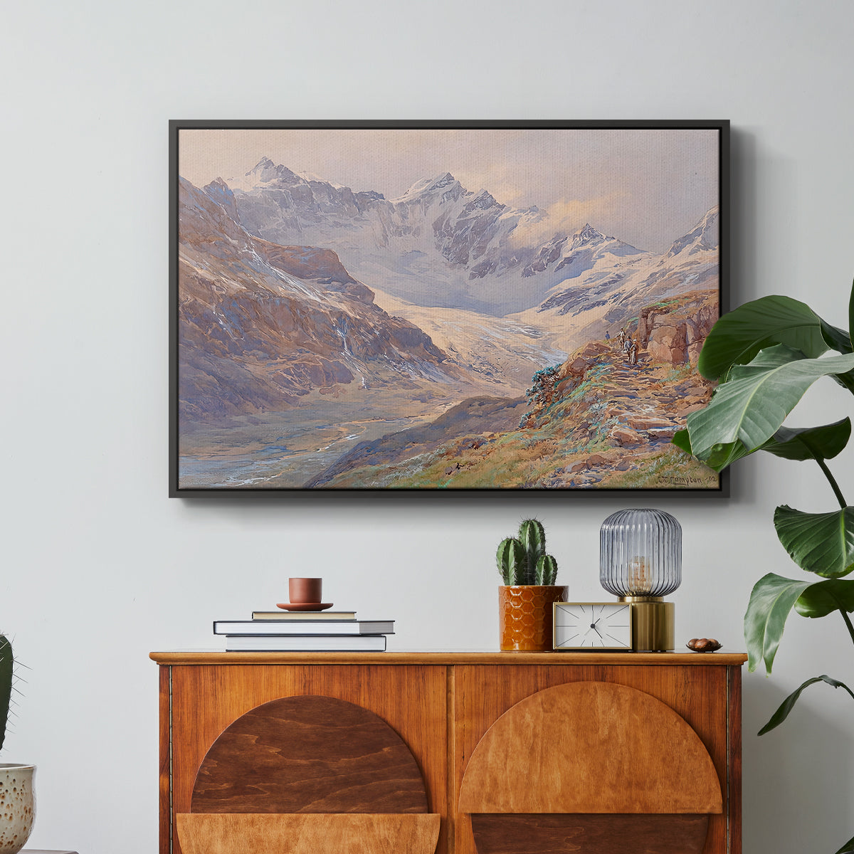 Odenwinklkees with the Johannisberg, 1902 by Edward Theodore Compton in a black floater framed canvas featuring an alpine glacier landscape with rugged peaks and snow-covered terrain, displayed above a wood console cabinet.