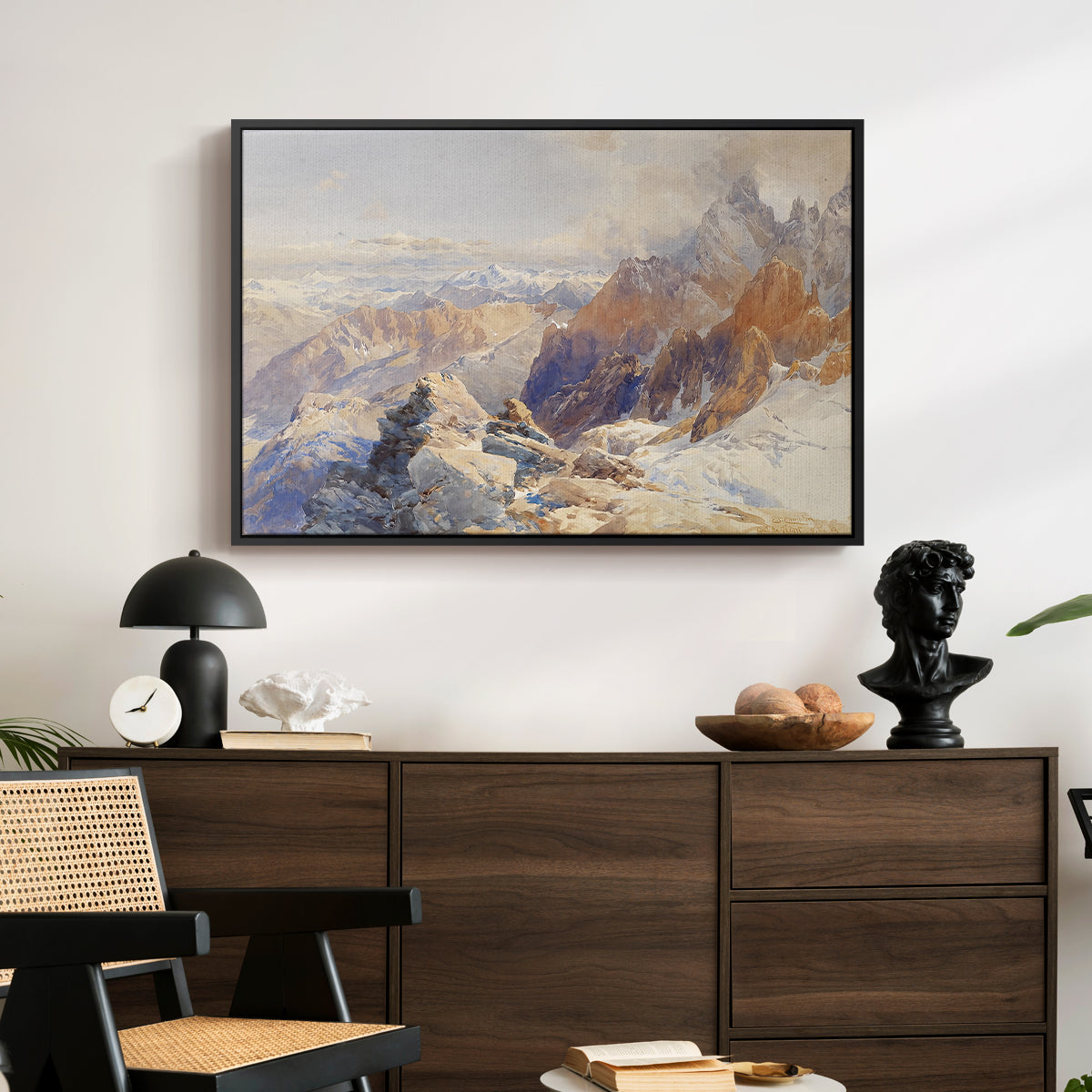 Col du Géant, 1903 by Edward Theodore Compton displayed in a black floater framed canvas above a dark wood credenza in an entryway.
