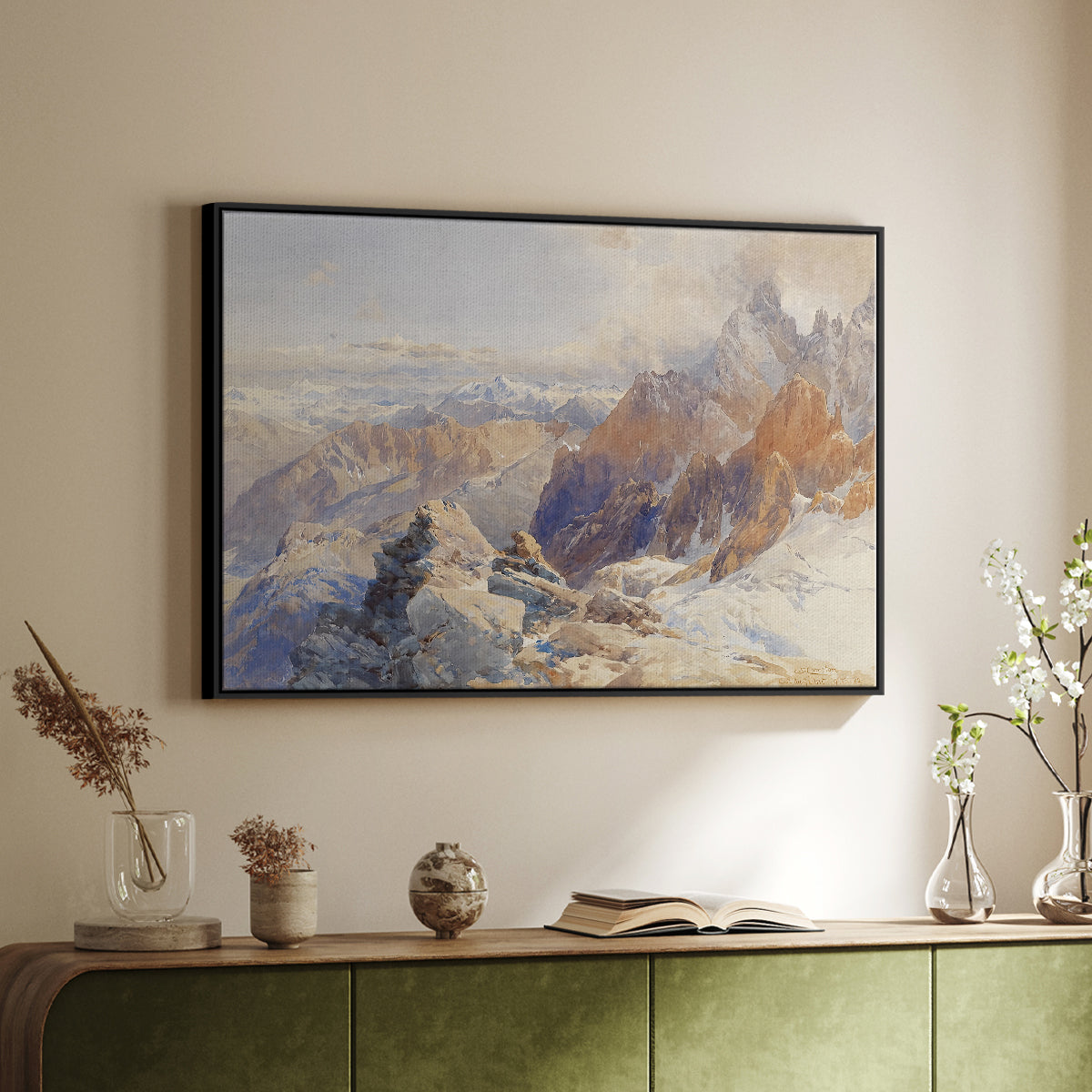 Black floater framed canvas of Col du Géant, 1903 by Edward Theodore Compton, featuring a high mountain landscape featuring dramatic ridges and glacier terrain above a sideboard in a softly lit hallway.
