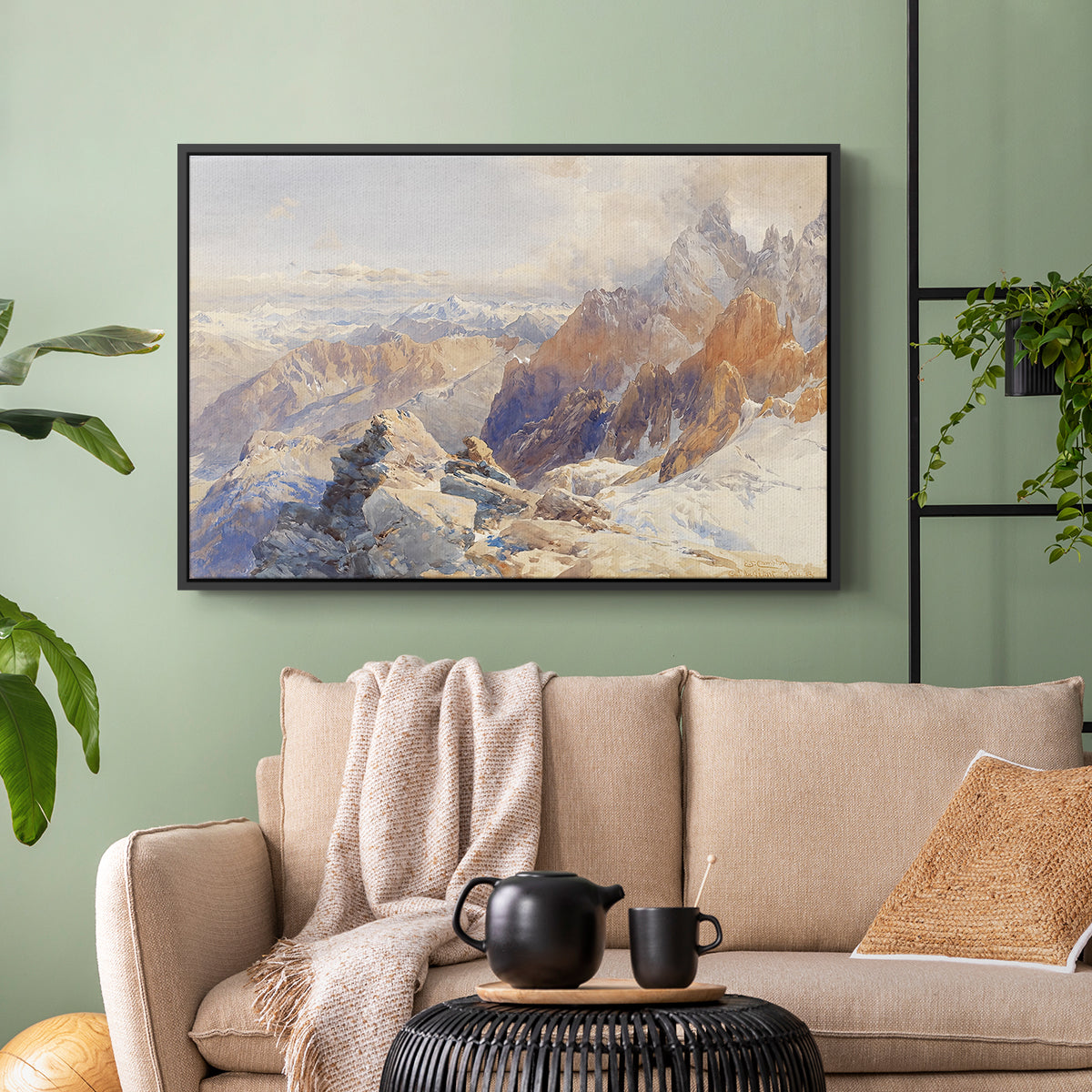 Black floater framed canvas featuring a rugged mountain pass scene with distant peaks, displayed above a sofa in a modern living room.