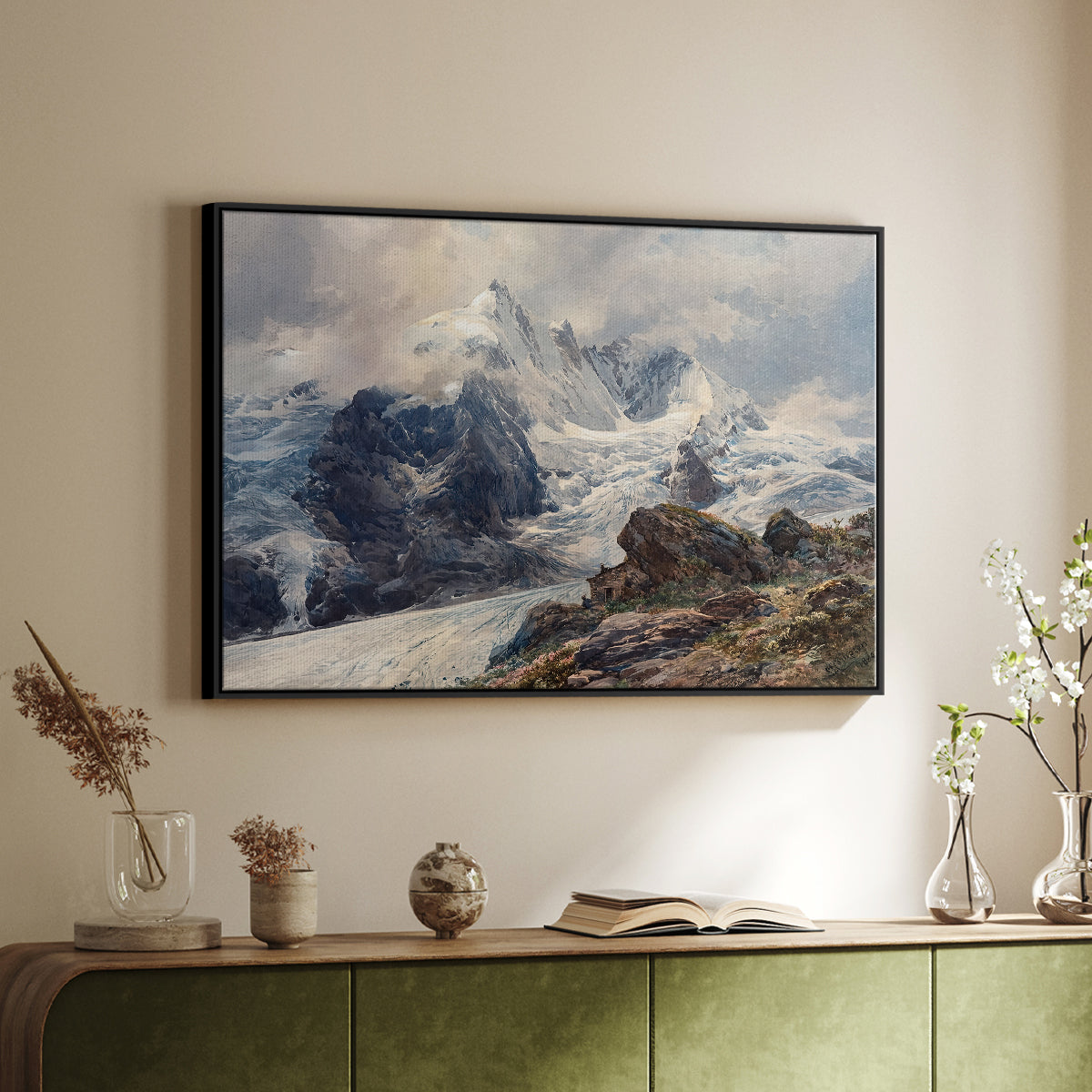 Black floater framed canvas of The Grossglockner, 1880 by Edward Theodore Compton, featuring a dramatic mountain summit with snow and rugged slopes above a sideboard in a softly lit hallway.