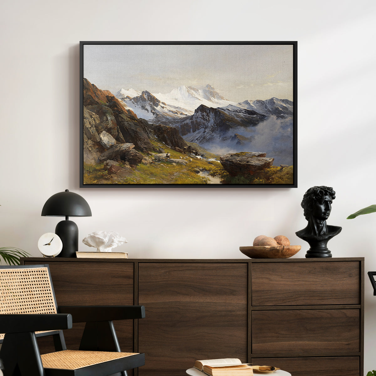 The Großglockner from the Prager Hut, 1890 by Edward Theodore Compton displayed in a black floater framed canvas above a dark wood credenza in an entryway.