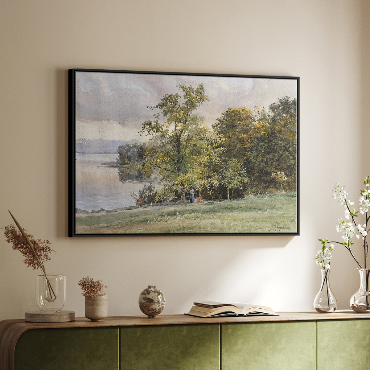 Black floater framed canvas of Landscape at Lake Starnberg, 1890 by Edward Theodore Compton, featuring a peaceful lake scene with reflections and surrounding greenery above a sideboard in a softly lit hallway.