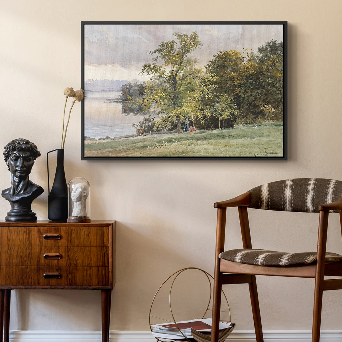 Landscape at Lake Starnberg, 1890 by Edward Theodore Compton as a black floater framed canvas featuring a natural setting with water, trees, and open sky, styled above a mid-century console in a contemporary living area.