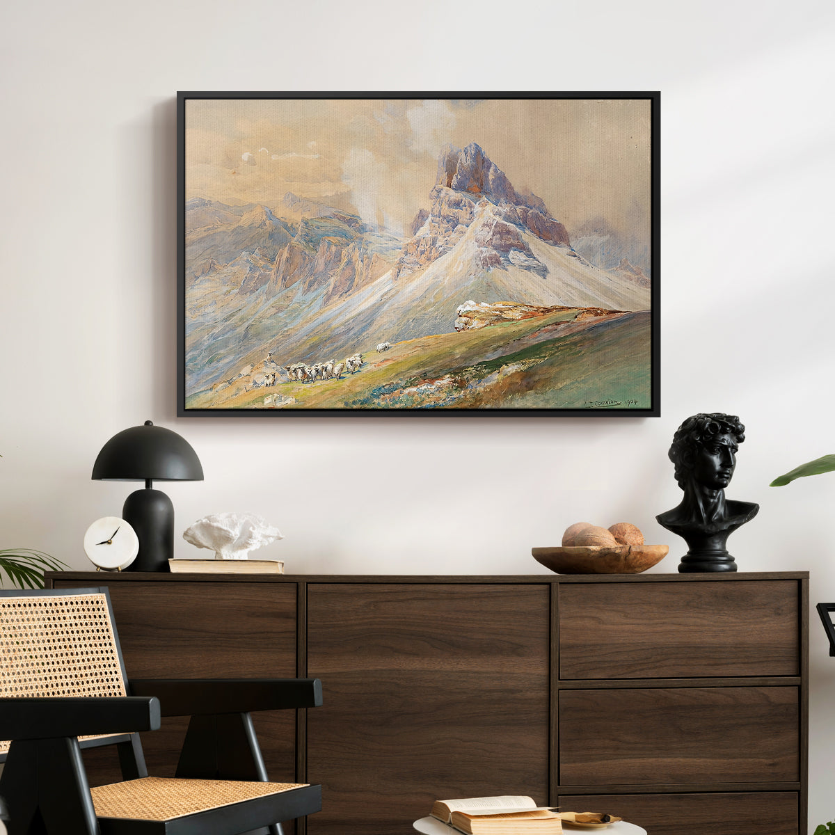 From the Dolomites, 1904 by Edward Theodore Compton displayed in a black floater framed canvas above a dark wood credenza in an entryway.