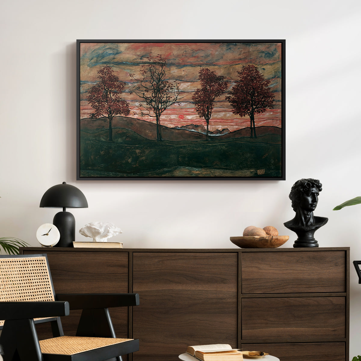 Four Trees, 1917 by Egon Schiele displayed in a black floater framed canvas above a dark wood credenza in an entryway.
