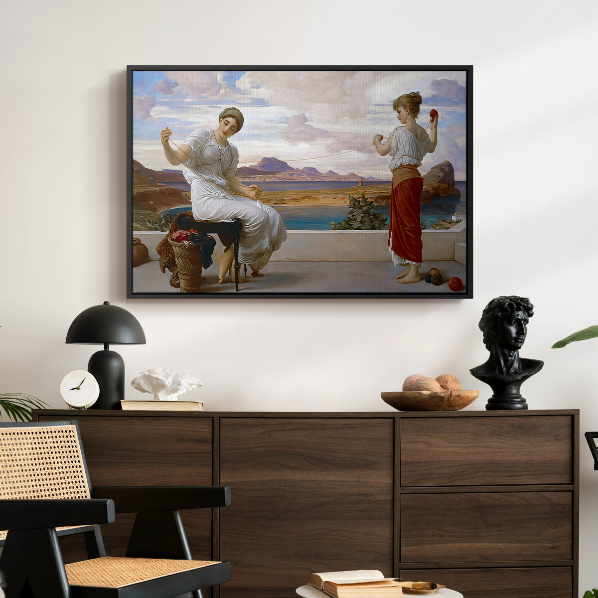 Winding the Skein, c. 1878 by Frederic Leighton displayed in a black floater framed canvas above a dark wood credenza in an entryway.