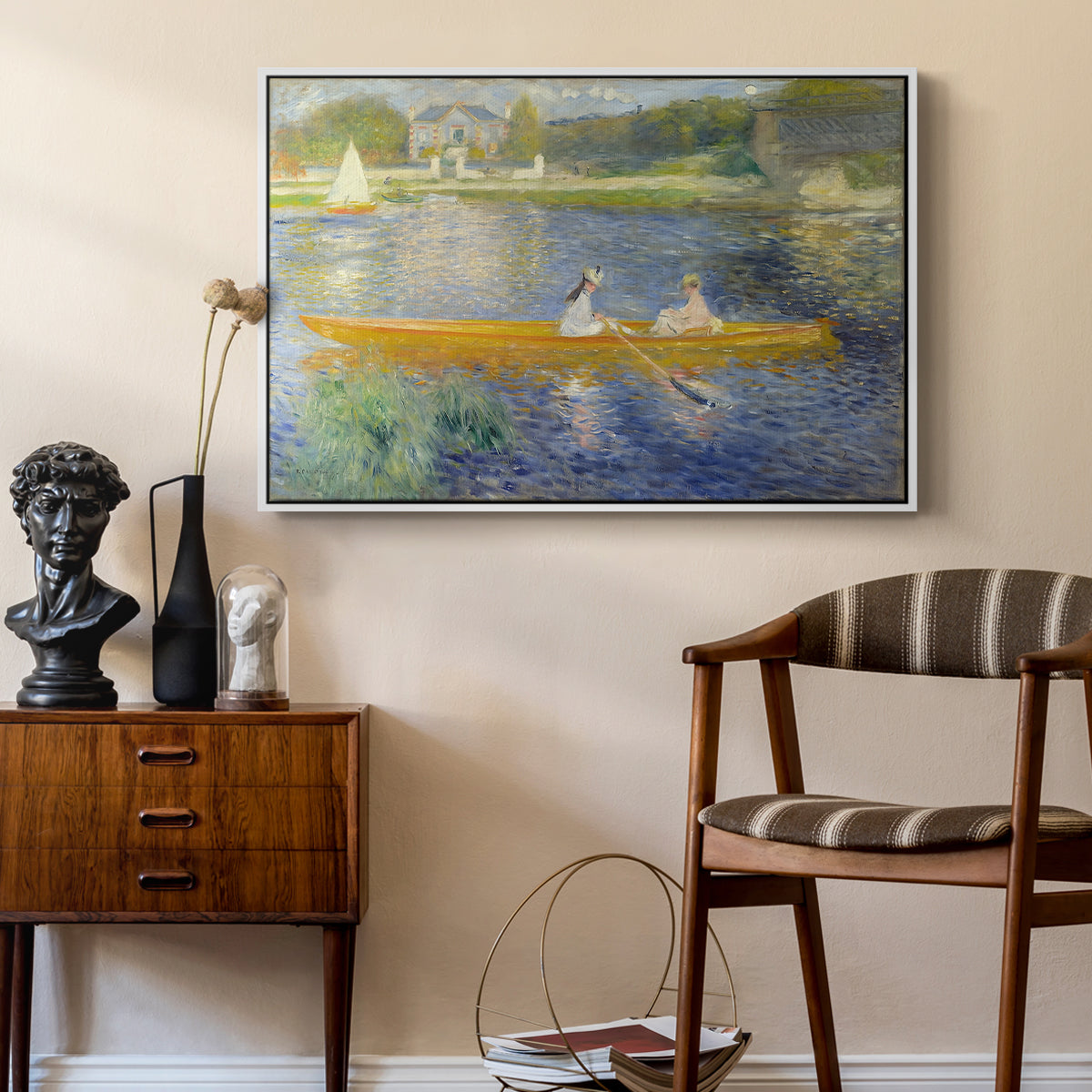 The Skiff (La Yole), 1875 by Pierre-Auguste Renoir as a white floater framed canvas featuring a couple seated in boat on river surrounded by soft reflections, styled above a mid-century console in a contemporary living area.