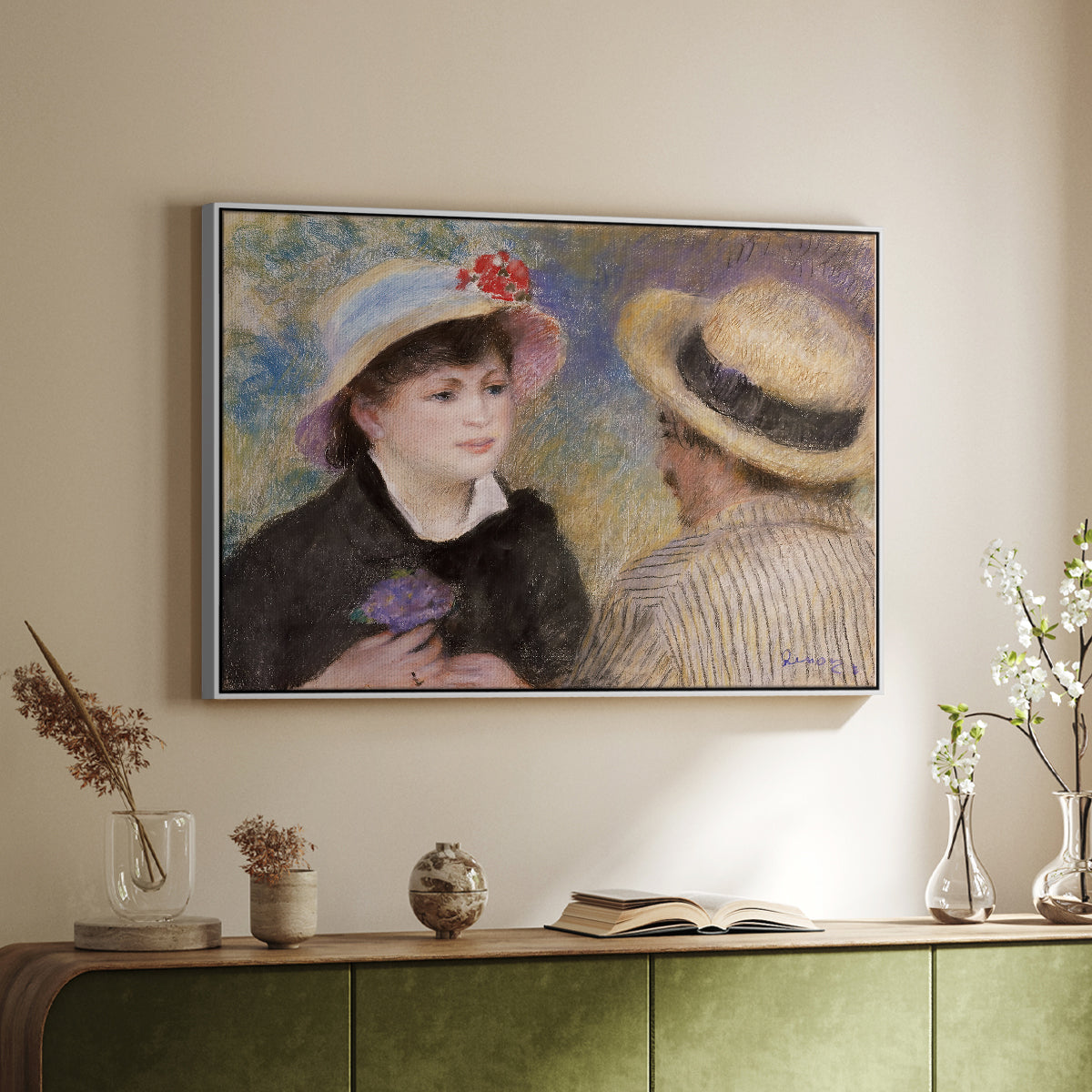 White floater framed canvas of Boating Couple (Aline Charigot and Renoir), c. 1881 by Pierre-Auguste Renoir, featuring an intimate portrait of man and woman sitting side by side in outdoor setting above a sideboard in a softly lit hallway.