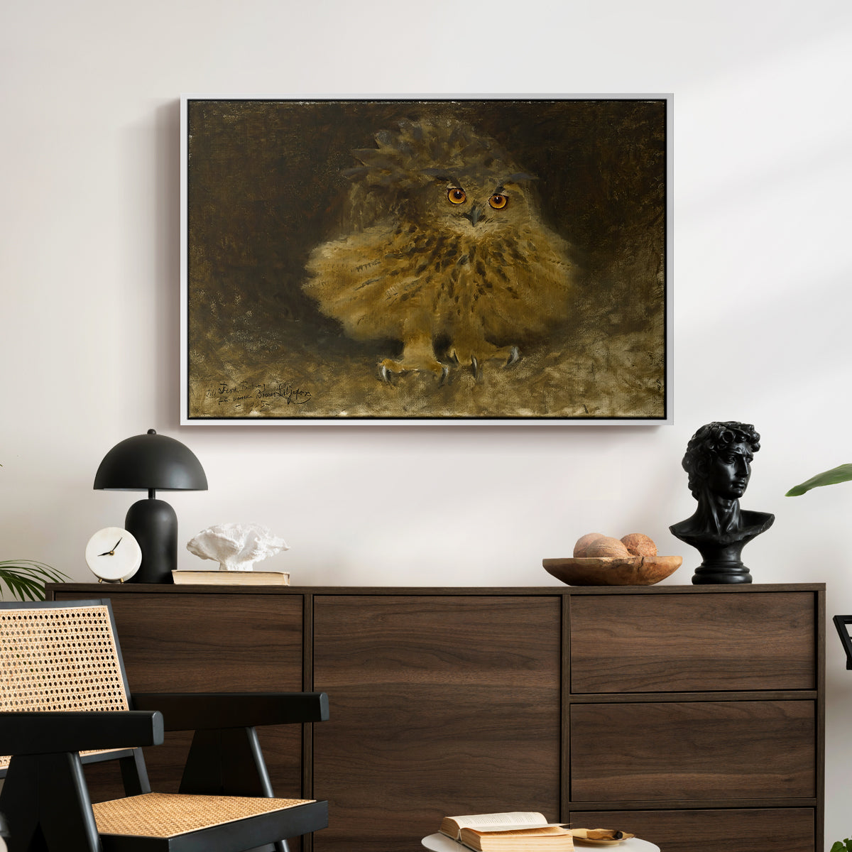 An Eagle Owl (Berguv), 1905 by Bruno Liljefors displayed in a white floater framed canvas above a dark wood credenza in an entryway.