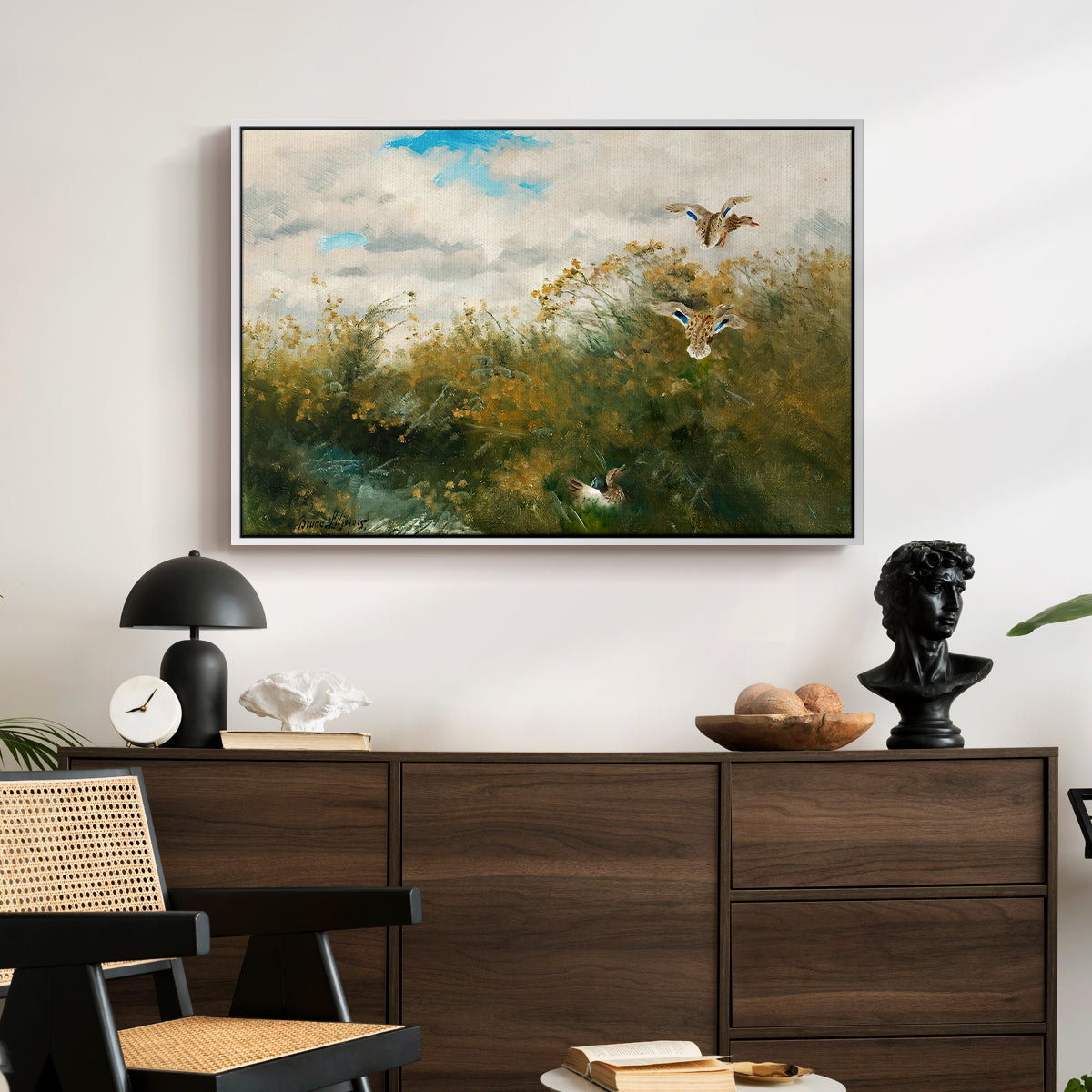 Wild Ducks (Grasänder), 1890 by Bruno Liljefors displayed in a white floater framed canvas above a dark wood credenza in an entryway.