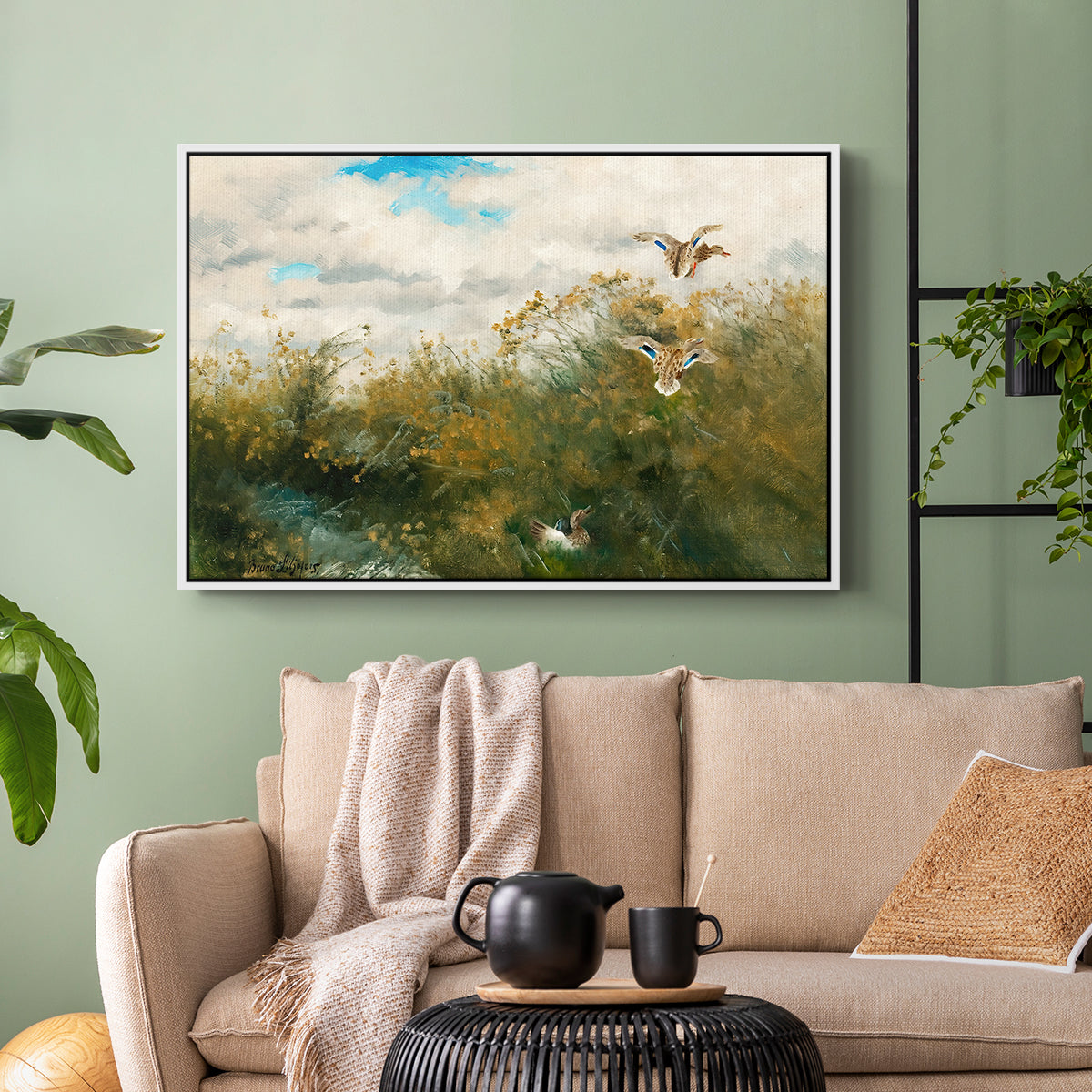 White floater framed canvas featuring a realistic depiction of ducks in countryside landscape, displayed above a sofa in a modern living room.