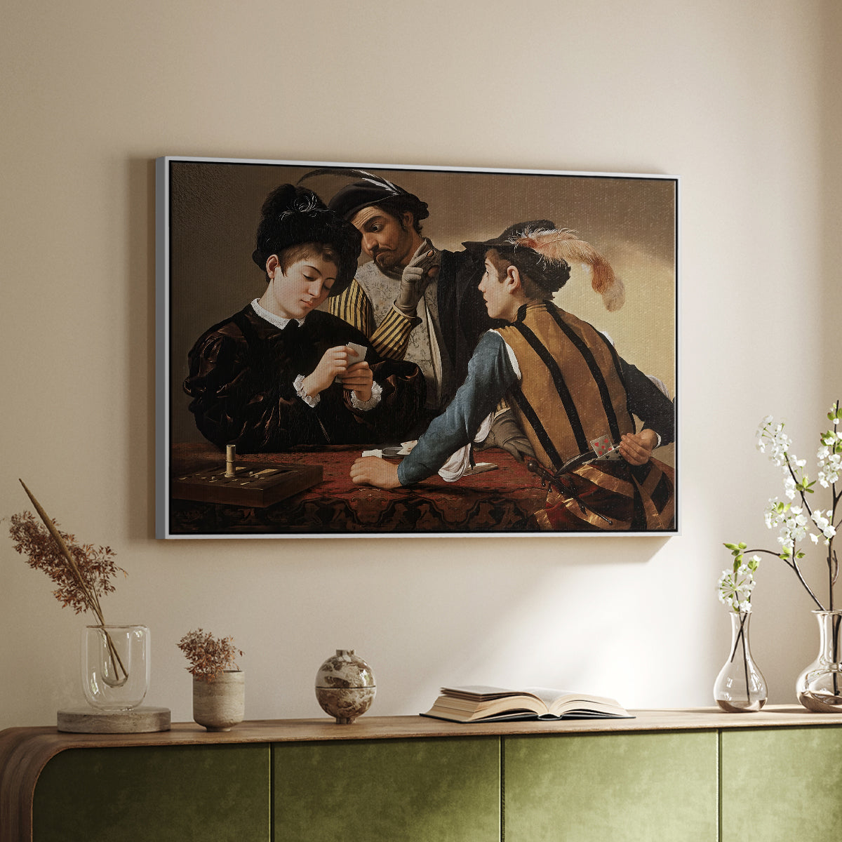 White floater framed canvas of The Cardsharps, c. 1594 by Caravaggio, featuring a genre scene of card game with deception and hidden accomplice above a sideboard in a softly lit hallway.