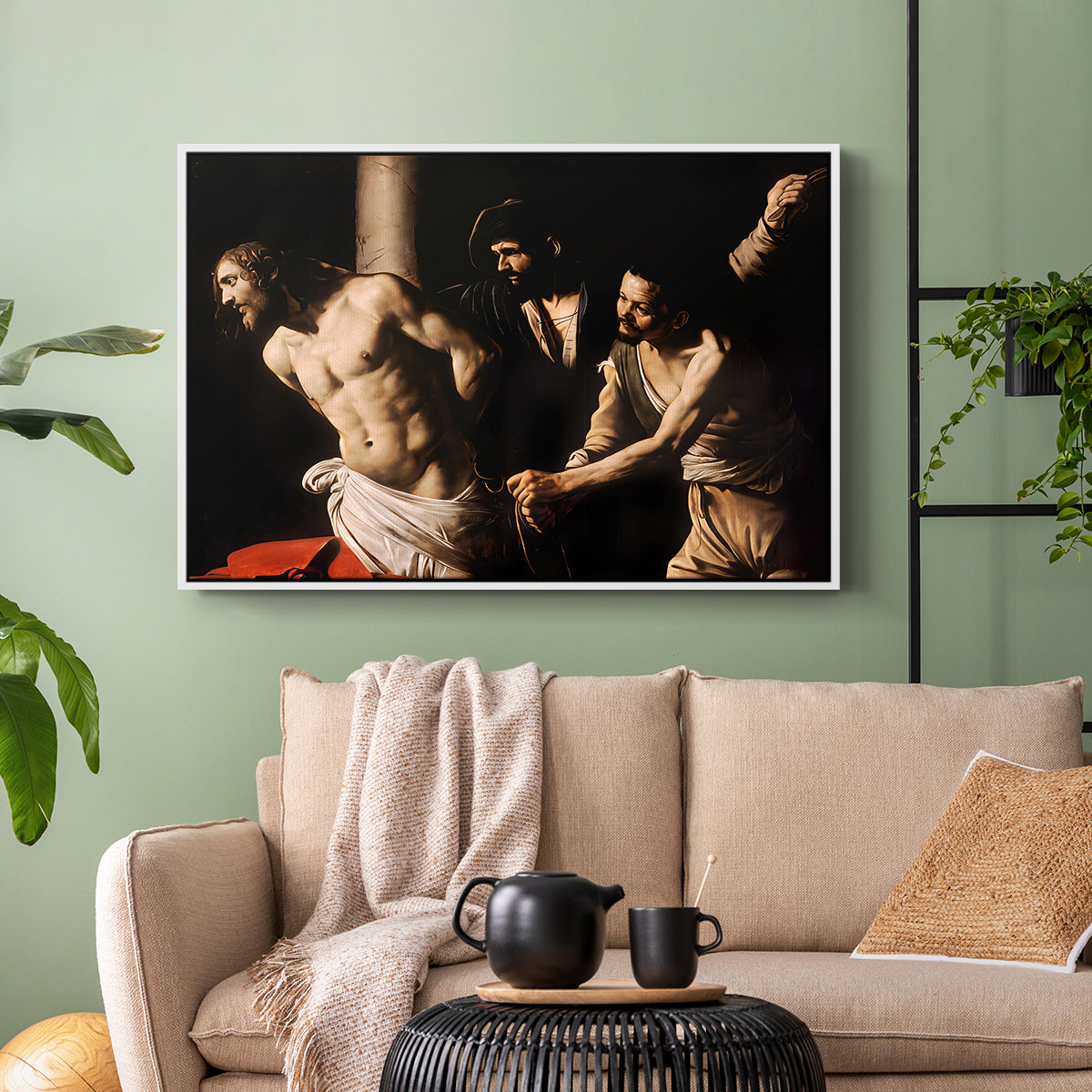 White floater framed canvas featuring an intense Baroque scene of suffering with strong light and shadow, displayed above a sofa in a modern living room.