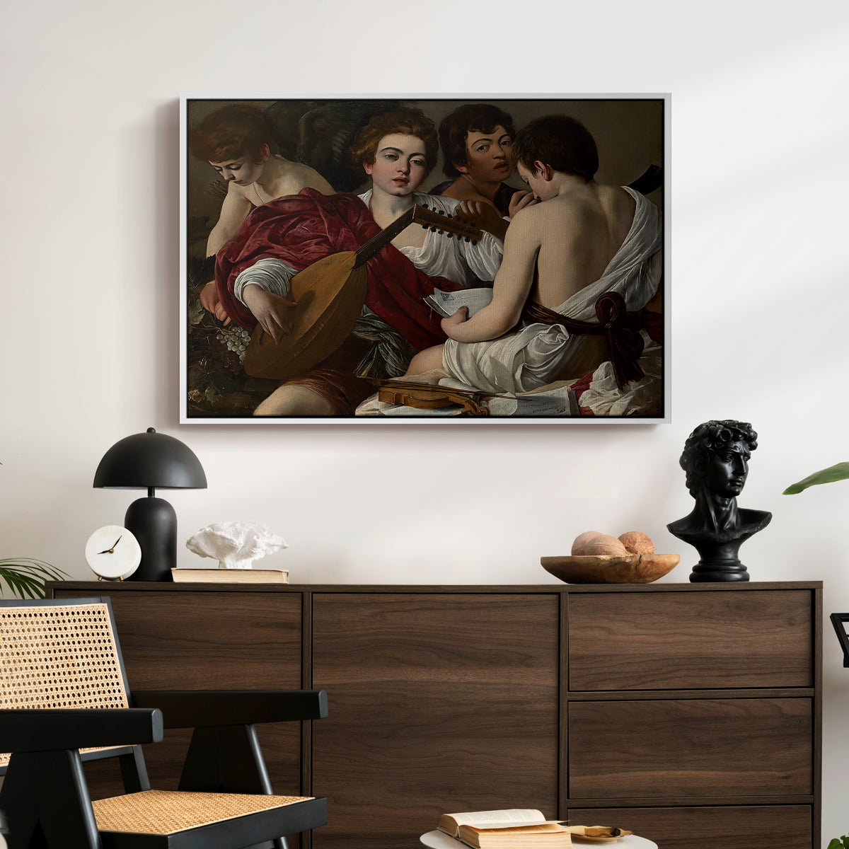 The Musicians, c. 1595 by Caravaggio displayed in a white floater framed canvas above a dark wood credenza in an entryway.