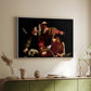 White floater framed canvas of The Sacrifice of Isaac (Uffizi Version), c. 1603 by Caravaggio, featuring a biblical scene of father about to sacrifice son as angel restrains him above a sideboard in a softly lit hallway.