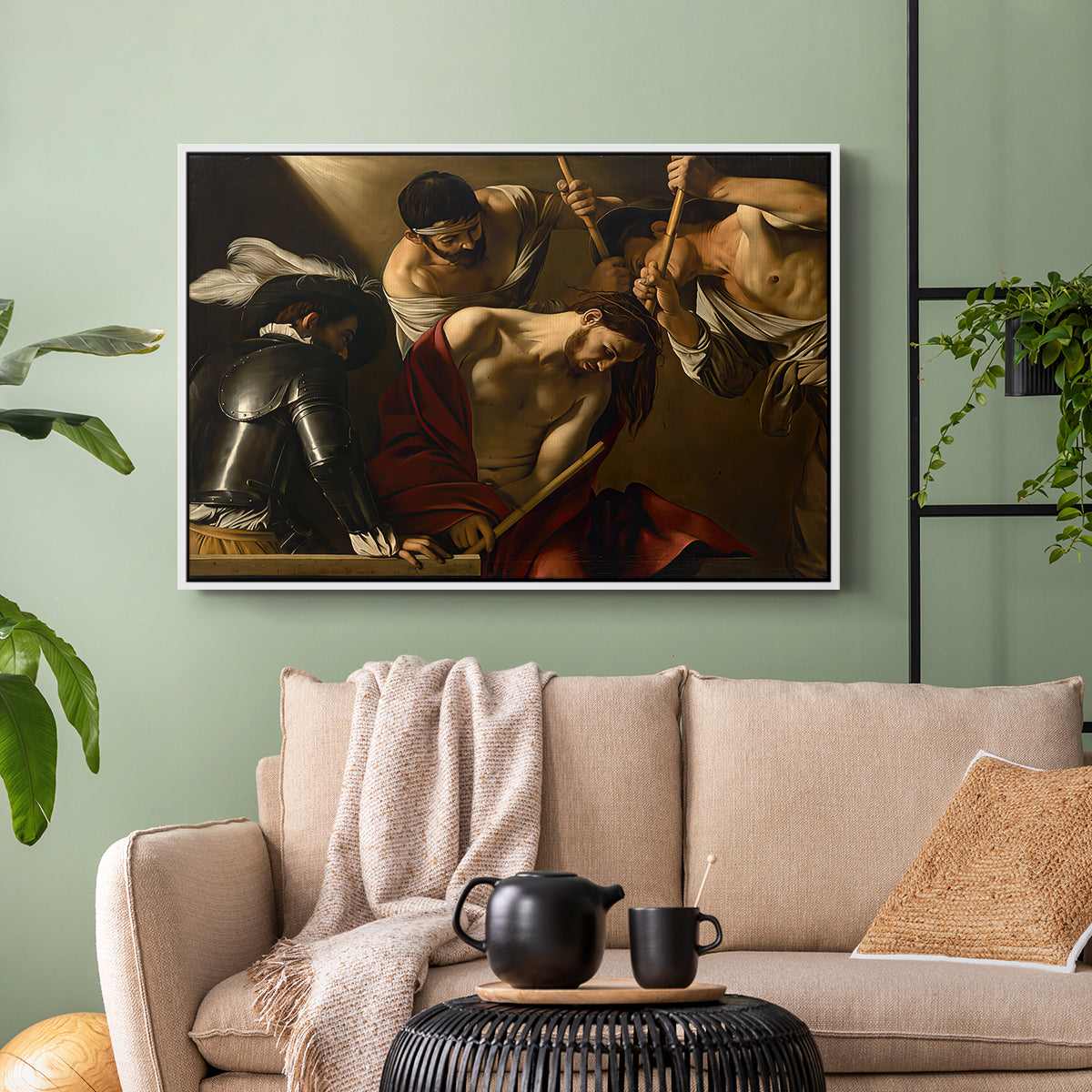 White floater framed canvas featuring an intense religious composition with strong shadow and physical struggle, displayed above a sofa in a modern living room.