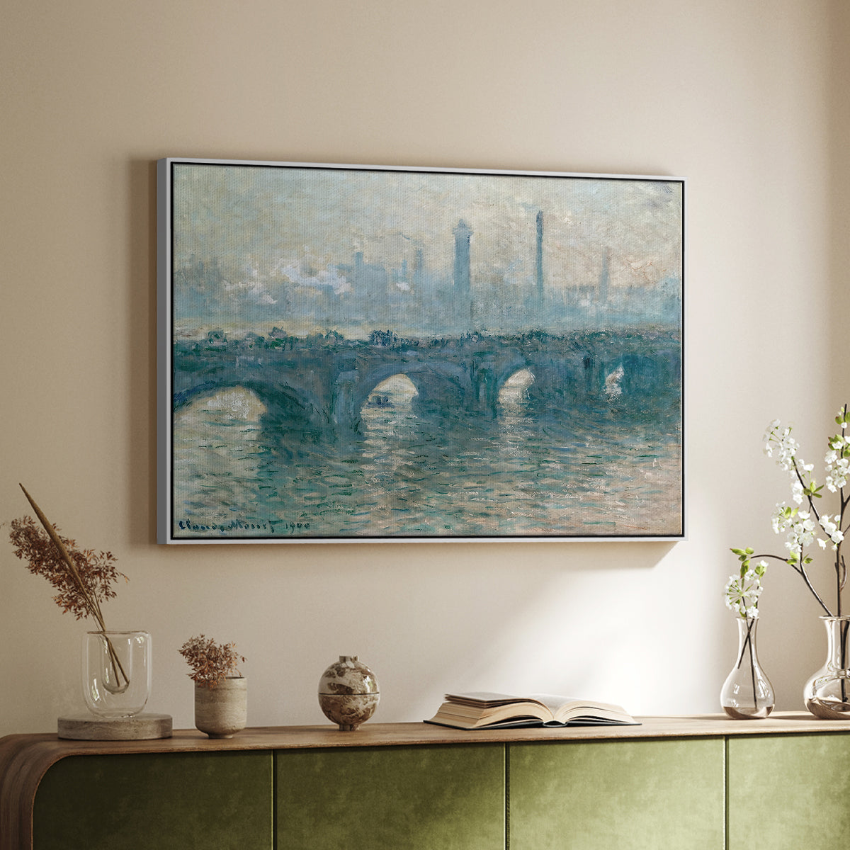 White floater framed canvas of Waterloo Bridge, Gray Weather, 1900 by Claude Monet, featuring an impressionist cityscape with bridge fading into fog over water above a sideboard in a softly lit hallway.
