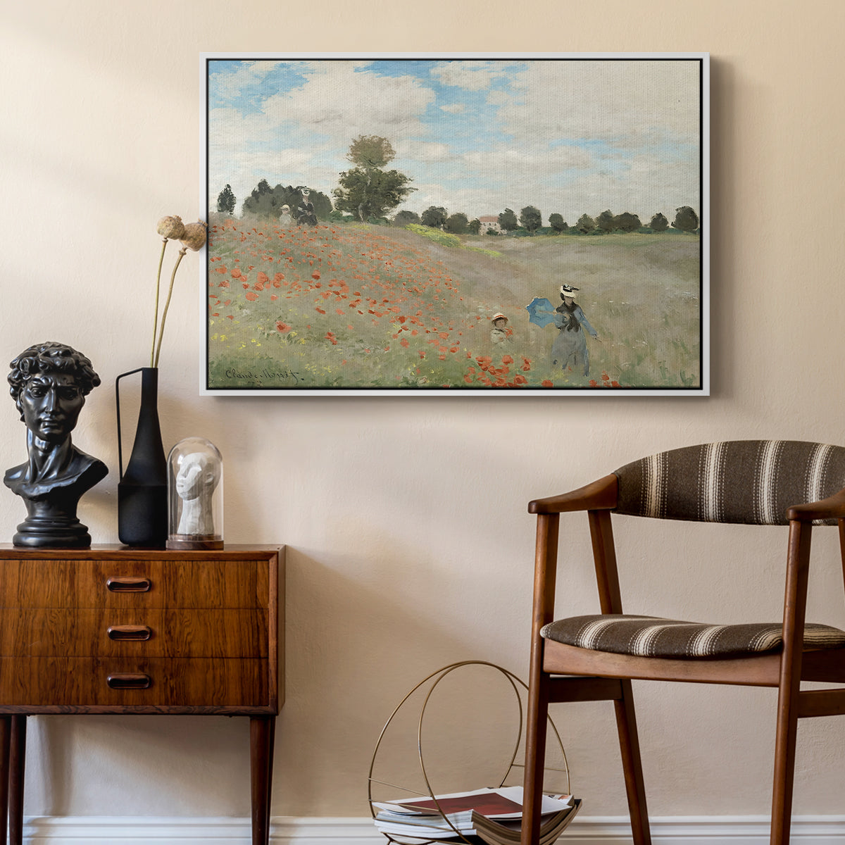 The Poppy Field near Argenteuil, 1873 by Claude Monet as a white floater framed canvas featuring a bright meadow filled with poppies under open sky, styled above a mid-century console in a contemporary living area.