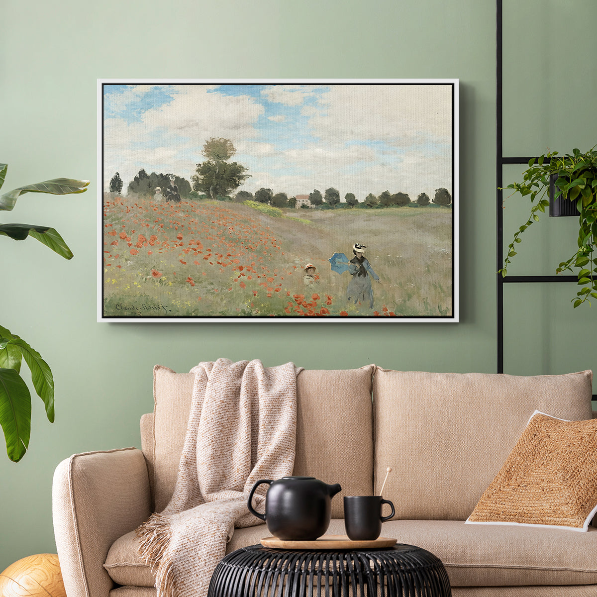 White floater framed canvas featuring a rural landscape with scattered figures among blooming flowers, displayed above a sofa in a modern living room.