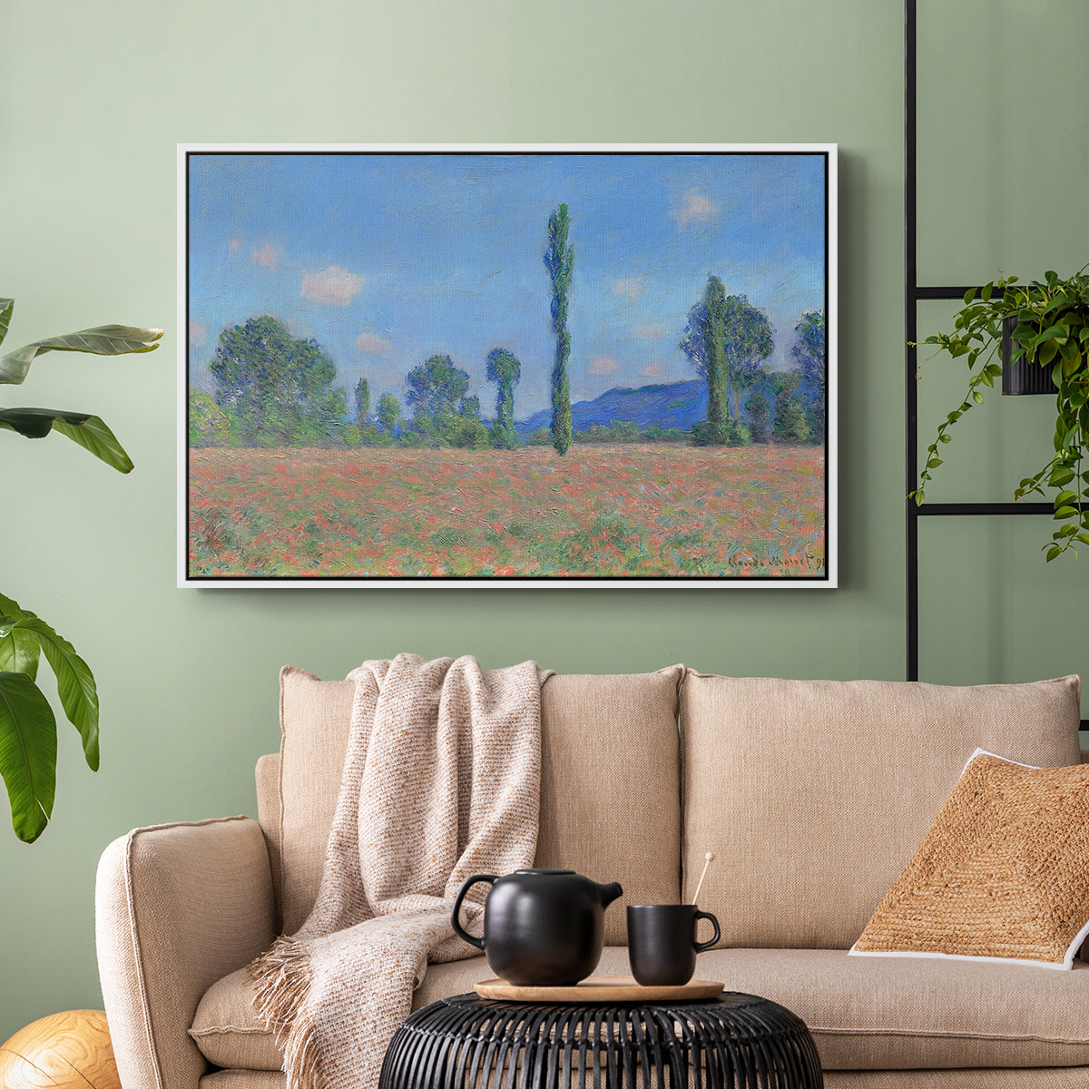 White floater framed canvas featuring a rural field filled with red blossoms beneath open sky, displayed above a sofa in a modern living room.