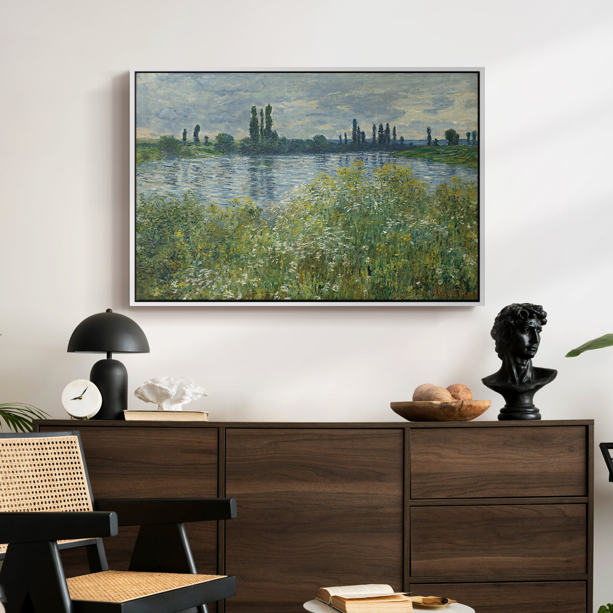 Banks of the Seine, Vétheuil, 1880 by Claude Monet displayed in a white floater framed canvas above a dark wood credenza in an entryway.