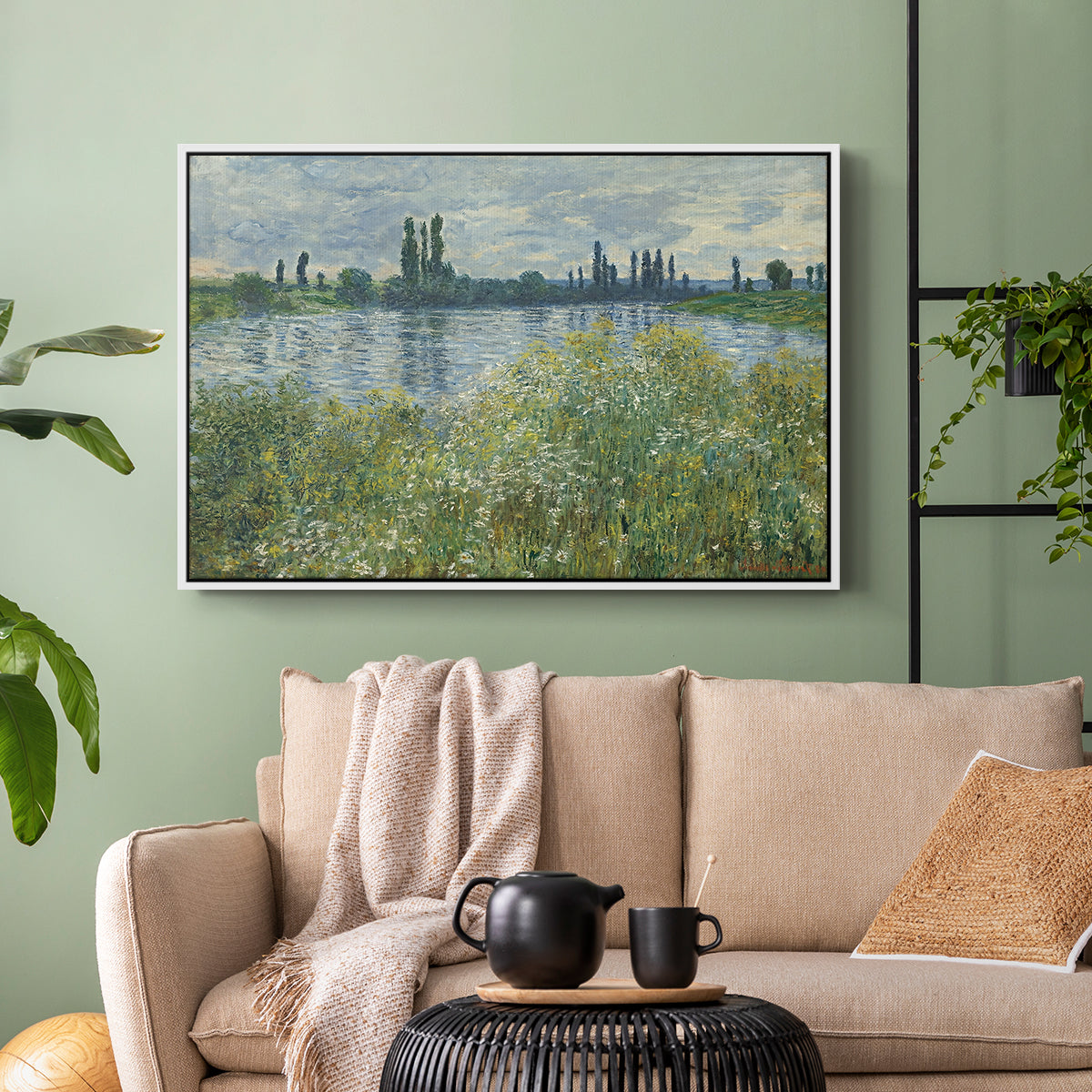 White floater framed canvas featuring a natural landscape with calm water and soft foliage, displayed above a sofa in a modern living room.