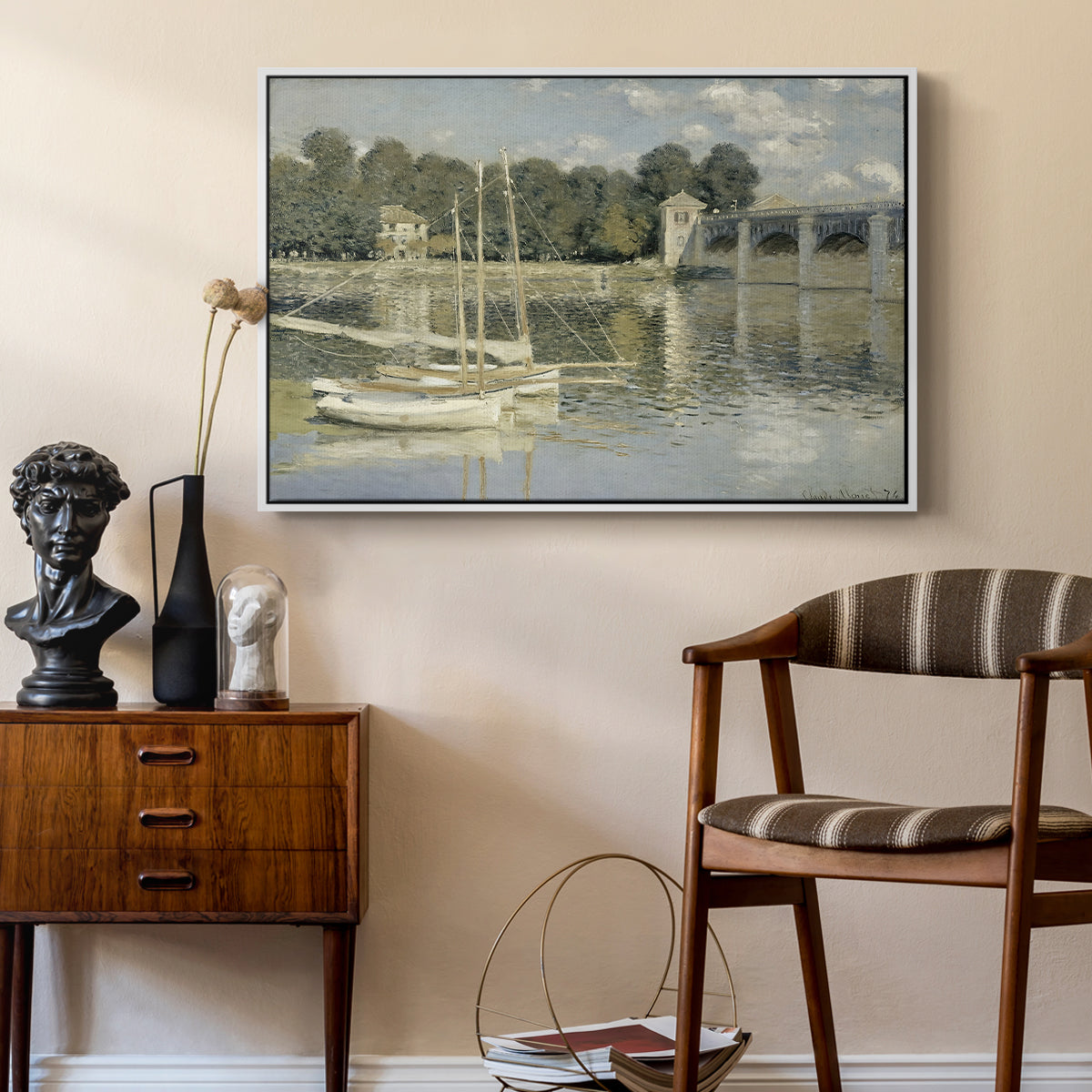 The Bridge at Argenteuil, 1874 by Claude Monet as a white floater framed canvas featuring a bright landscape featuring bridge and sailboats on calm water, styled above a mid-century console in a contemporary living area.