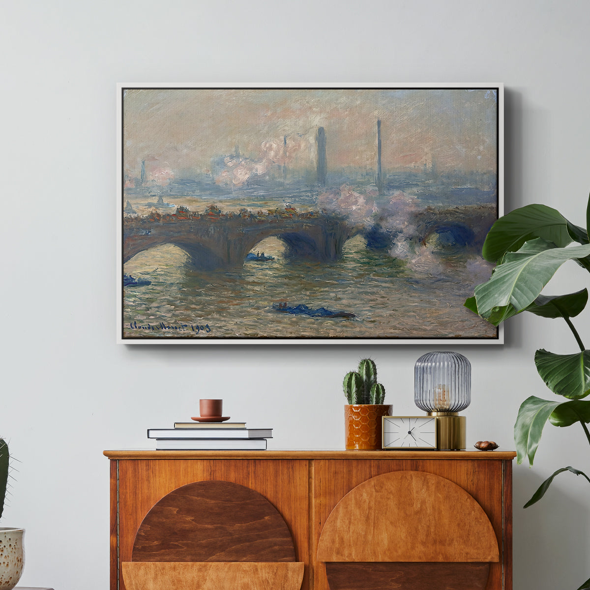 Waterloo Bridge, Gray Day, 1903 by Claude Monet in a white floater framed canvas featuring a muted cityscape of bridge spanning river under overcast sky, displayed above a wood console cabinet.