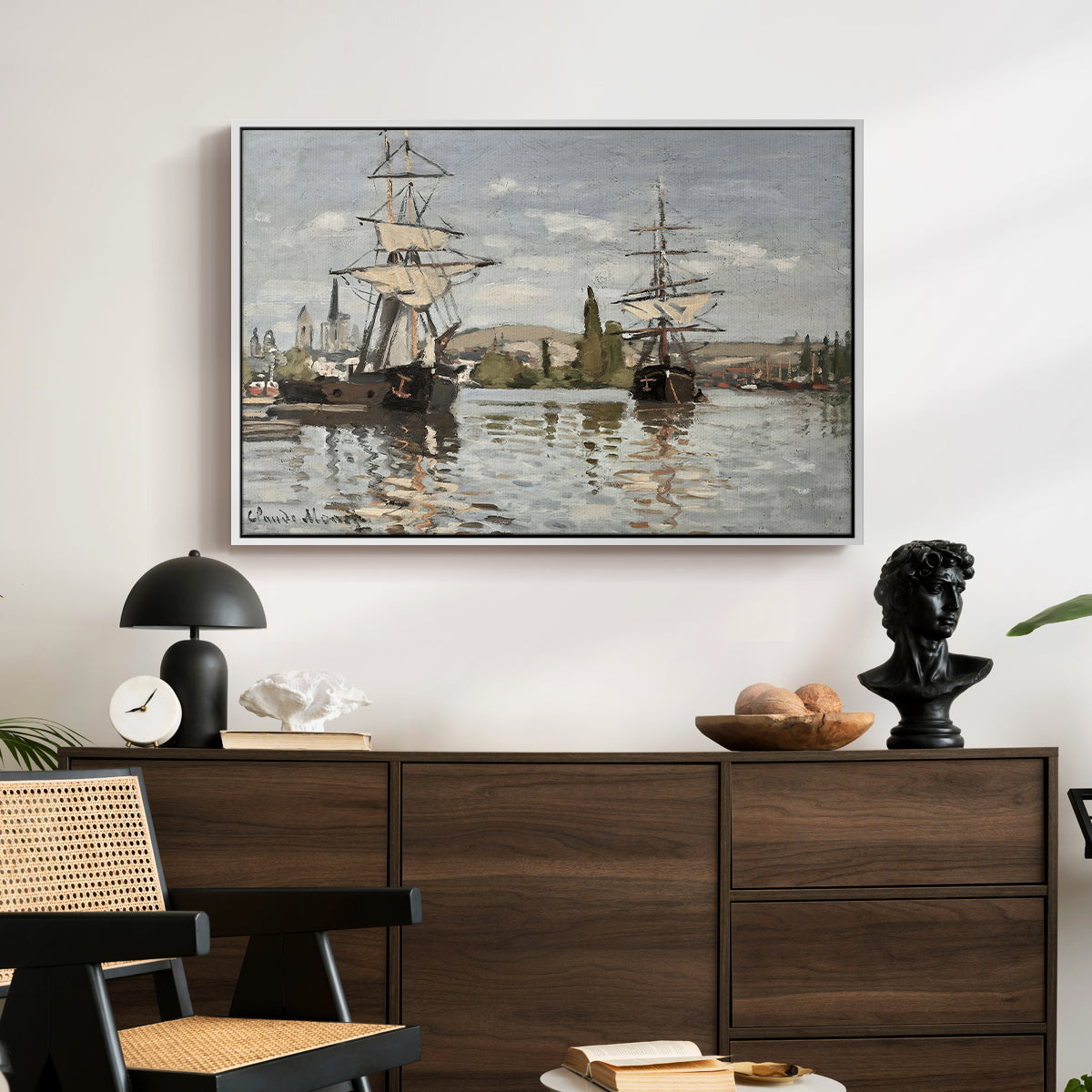 Ships Riding on the Seine at Rouen, 1872 by Claude Monet displayed in a white floater framed canvas above a dark wood credenza in an entryway.