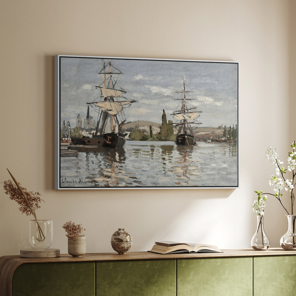 White floater framed canvas of Ships Riding on the Seine at Rouen, 1872 by Claude Monet, featuring an impressionist river scene with anchored sailing ships and reflections above a sideboard in a softly lit hallway.