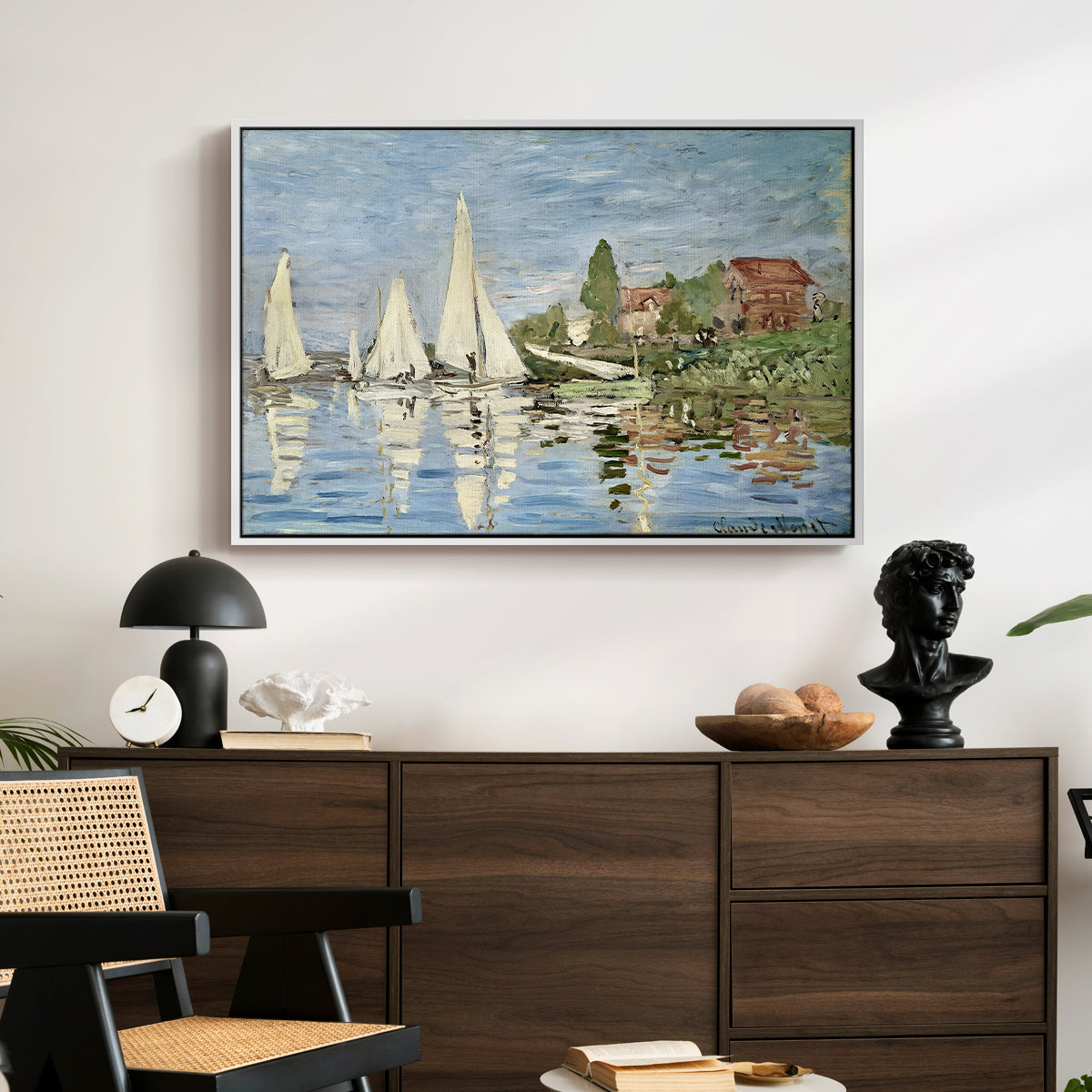 Regatta at Argenteuil, 1872 by Claude Monet displayed in a white floater framed canvas above a dark wood credenza in an entryway.