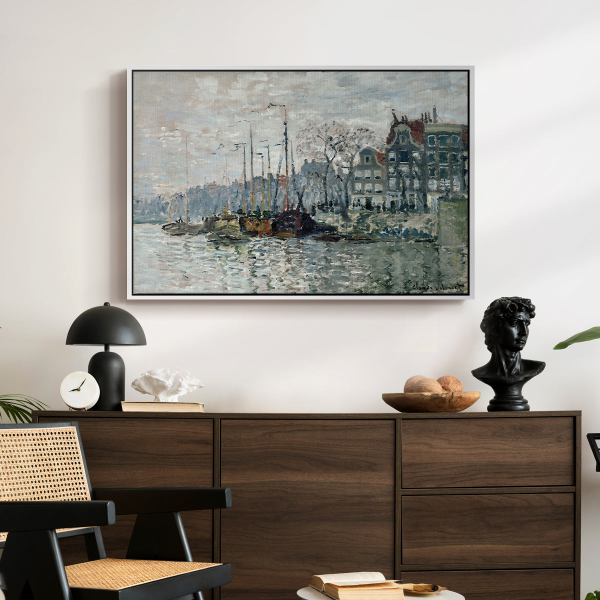 View of the Prins Hendrikkade and Kromme Waal in Amsterdam, 1874 by Claude Monet displayed in a white floater framed canvas above a dark wood credenza in an entryway.