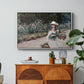 Young Girl in the Garden at Giverny, 1888 by Claude Monet in a white floater framed canvas featuring a young girl seated in lush garden surrounded by blooming flowers, displayed above a wood console cabinet.