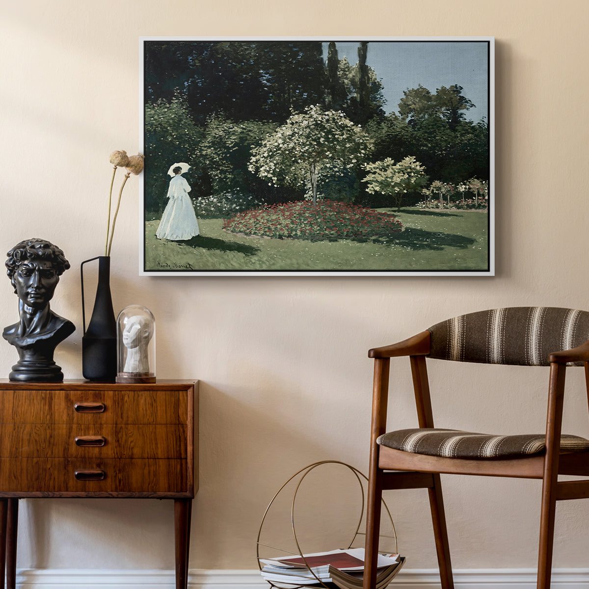 Woman in the Garden, Sainte-Adresse, 1867 by Claude Monet as a white floater framed canvas featuring an elegant woman posed outdoors among blooming plants, styled above a mid-century console in a contemporary living area.