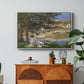 On the Bank of the Seine, Bennecourt, 1868 by Claude Monet in a white floater framed canvas featuring a woman and child seated along riverbank beneath trees in soft daylight, displayed above a wood console cabinet.