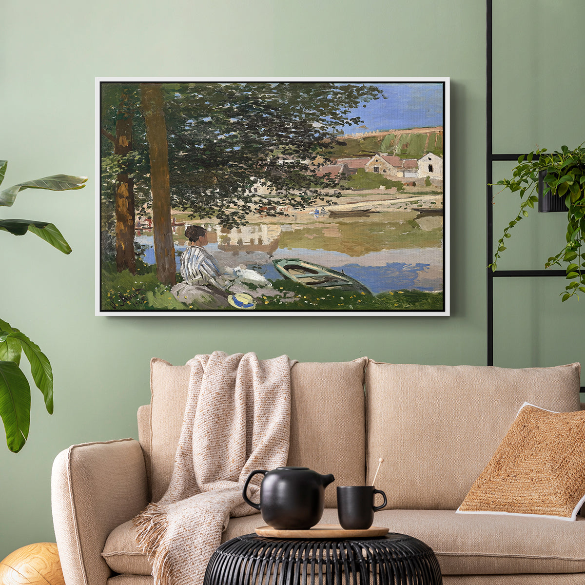 White floater framed canvas featuring a quiet outdoor setting with figures near river under foliage, displayed above a sofa in a modern living room.