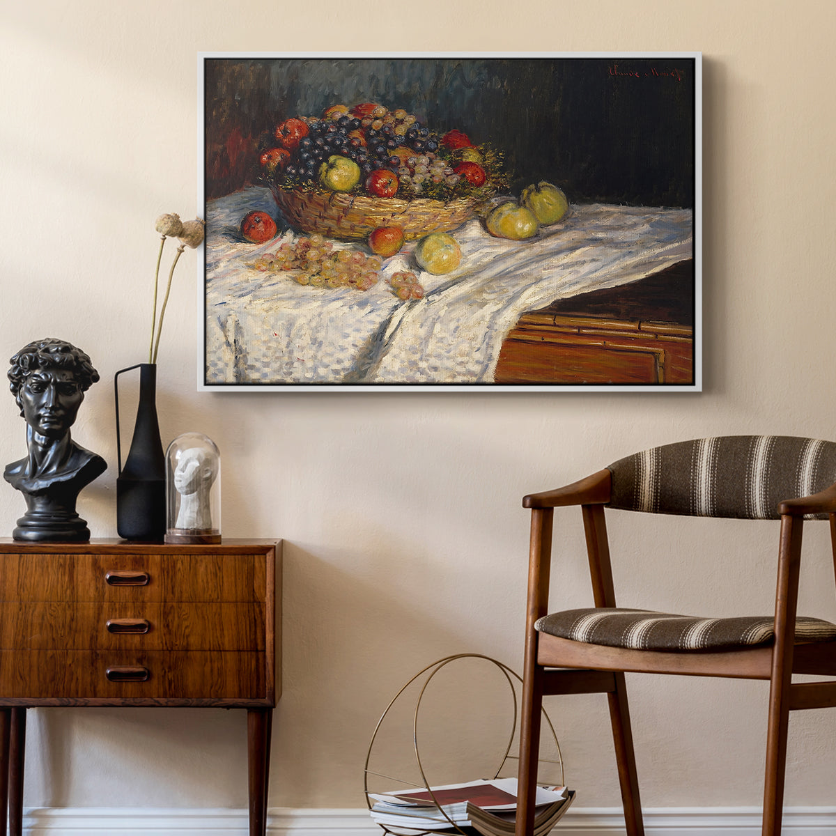 Still Life with Apples and Grapes, 1880 by Claude Monet as a white floater framed canvas featuring a close-up of apples and grapes in warm tones, styled above a mid-century console in a contemporary living area.
