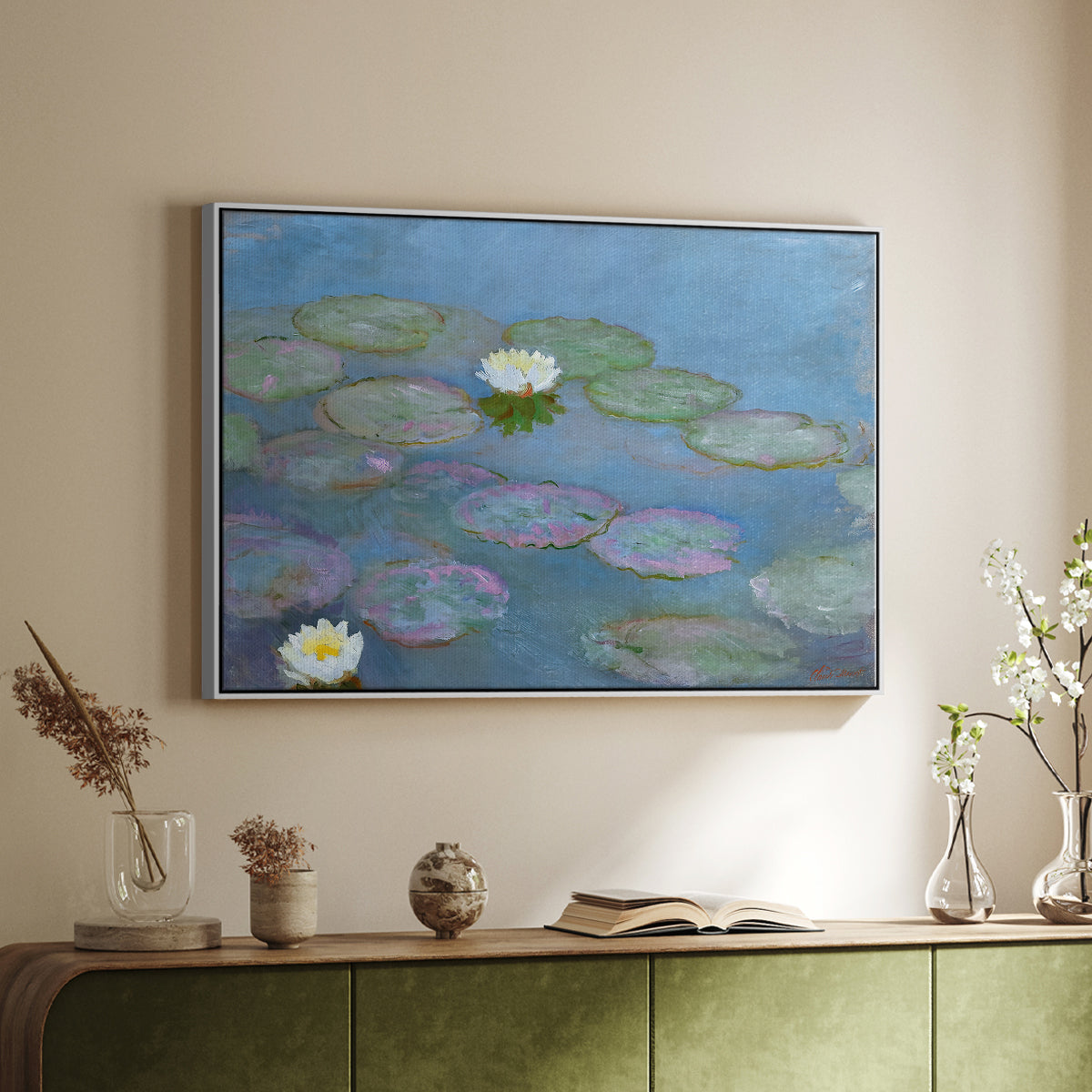 White floater framed canvas of Water Lilies (Nymphéas), 1897-1899 by Claude Monet, featuring an impressionist pond scene with lily pads and soft reflections above a sideboard in a softly lit hallway.