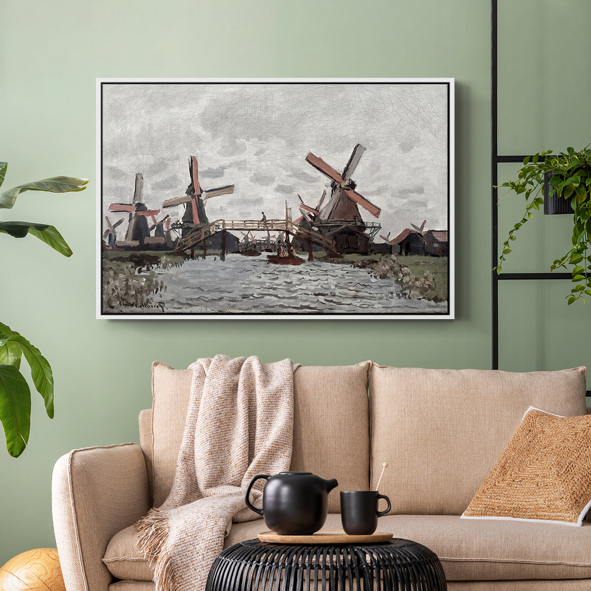 White floater framed canvas featuring a landscape featuring windmills and low horizon sky, displayed above a sofa in a modern living room.