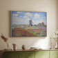 White floater framed canvas of Tulip Fields with the Rijnsburg Windmill, 1886 by Claude Monet, featuring a vibrant agricultural landscape with flowers and windmill above a sideboard in a softly lit hallway.