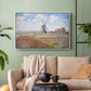 White floater framed canvas featuring a rural scene with patterned rows of flowers and windmill, displayed above a sofa in a modern living room.