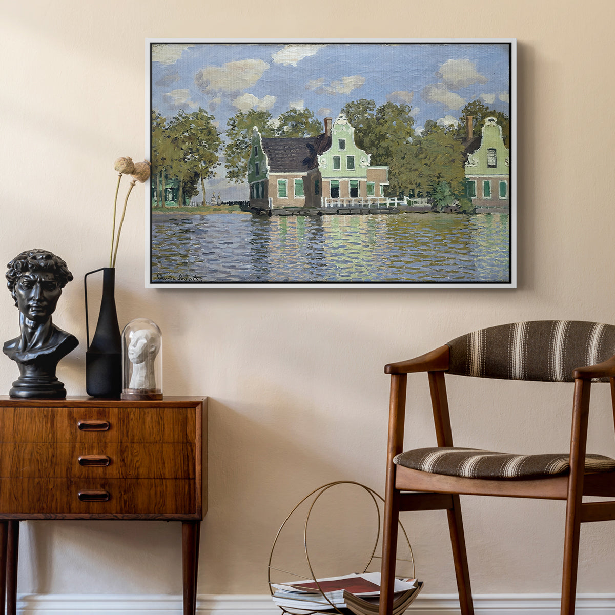 Houses on the Zaan River at Zaandam, 1871 by Claude Monet as a white floater framed canvas featuring a peaceful canal scene with houses mirrored in water, styled above a mid-century console in a contemporary living area.