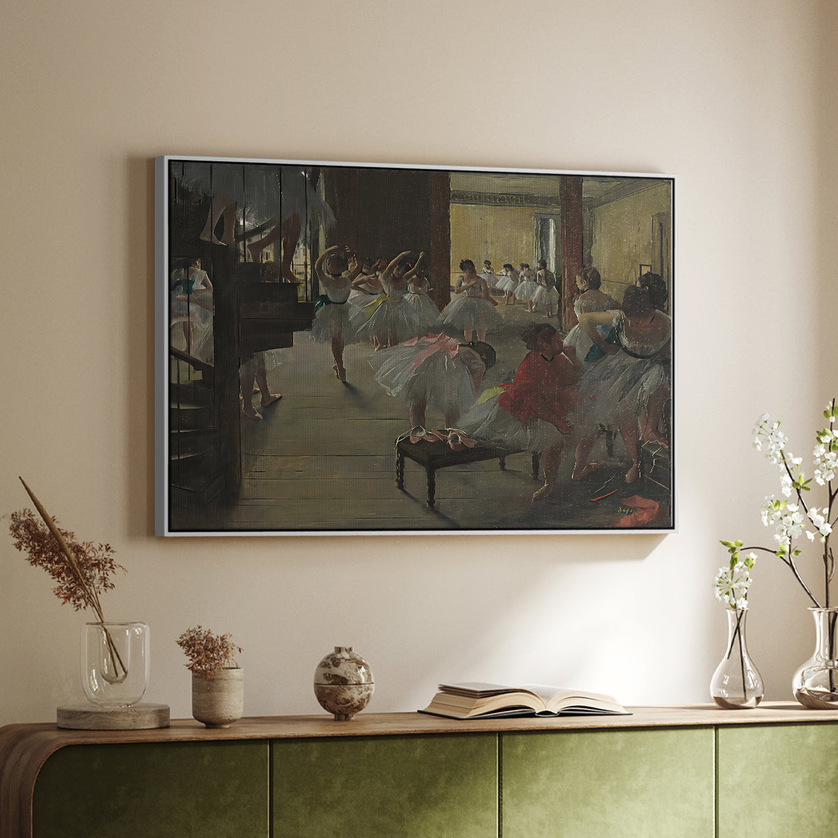 White floater framed canvas of The Dance Class, c. 1873 by Edgar Degas, featuring a rehearsal scene with dancers stretching and posing indoors above a sideboard in a softly lit hallway.
