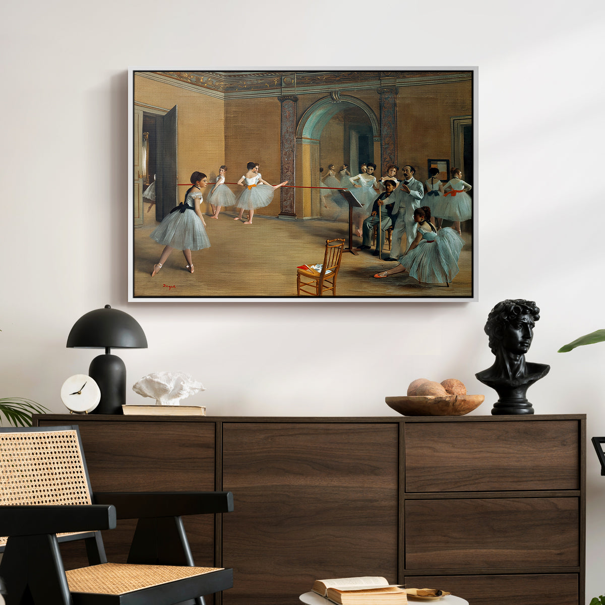 The Dance Foyer at the Opera on the Rue Le Peletier, 1872 by Edgar Degas displayed in a white floater framed canvas above a dark wood credenza in an entryway.