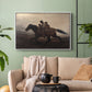 White floater framed canvas featuring figures on horse moving swiftly through shadowy landscape, displayed above a sofa in a modern living room.