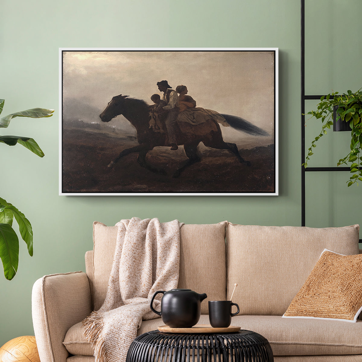 White floater framed canvas featuring figures on horse moving swiftly through shadowy landscape, displayed above a sofa in a modern living room.