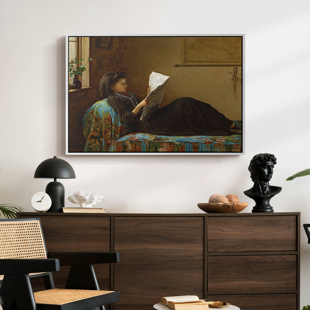 Interesting News, 1872 by Eastman Johnson displayed in a white floater framed canvas above a dark wood credenza in an entryway.