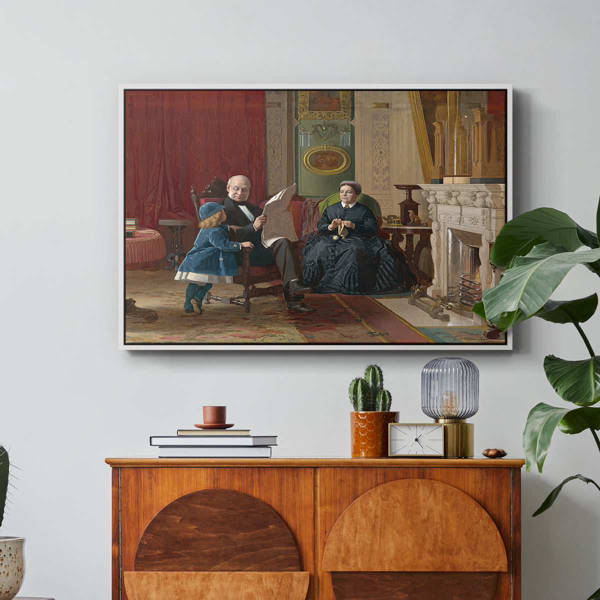 The Brown Family, 1869 by Eastman Johnson in a white floater framed canvas featuring a family seated together in interior room engaged in quiet activity, displayed above a wood console cabinet.